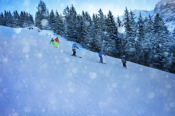 子供たちのためのスキースクール 子供たちのグループは雪の中で次々と坂を下ります — ストック写真