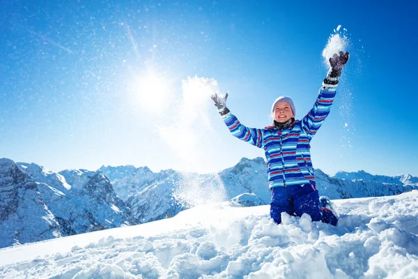 美丽的笑容可亲的女孩在阳光明媚的天空和群山上 把雪花抛向空中 — 图库照片