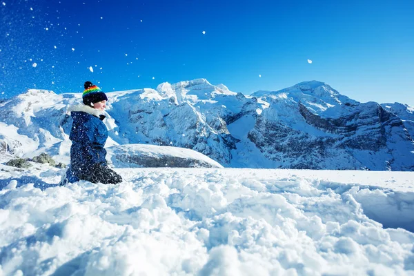 10代の少女のサイドポートレート背景に山の峰の上に空気中の雪を投げる — ストック写真