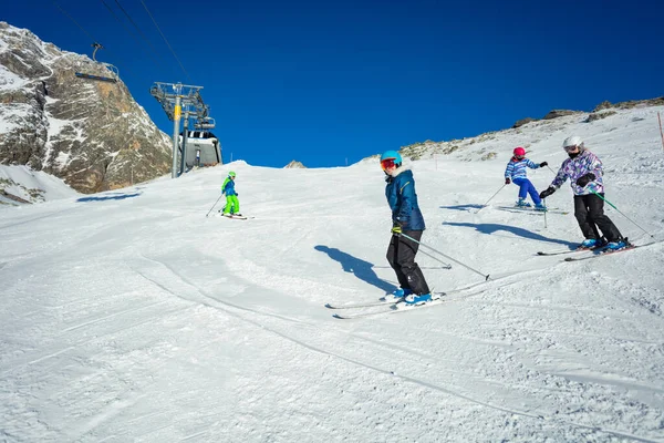 一群孩子一个接一个地在学校形成的阿尔卑斯山坡上滑行 — 图库照片
