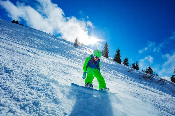 活泼的男孩在雪板上走得快 在蓝天和滑雪场上到处撒雪 在蓝天和滑雪场上的运动图像 — 图库照片