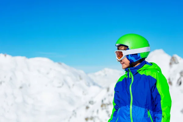 スポーツヘルメットやスキーやスノーボードの眼鏡で明るい日当たりの良い山の雪の上に男の子の近い側の肖像画を背景に — ストック写真