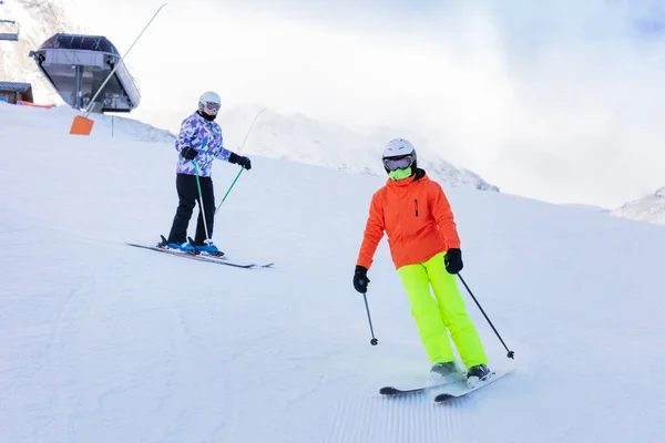 Två Tjejer Åker Utför Tillsammans Färgglada Kläder Alpina Bergssluttningen — Stockfoto