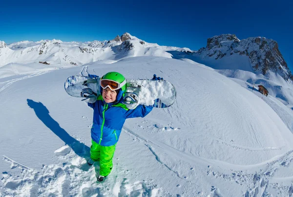 大きな山のパノラマとかわいい笑顔の男の子はマスクをオフにして上から肩のビューでスノーボードを保持します — ストック写真