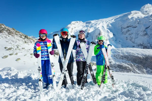 スキースクールグループのコンセプト 4つの幸せな子供たちは彼らがリーンと笑顔の前に機器を保持スタンド — ストック写真