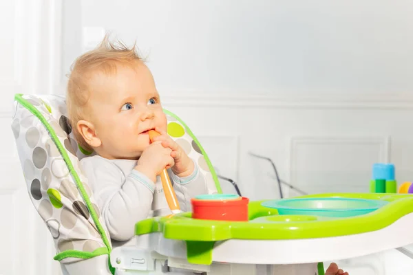 Feliz Niño Pequeño Niño Sienta Silla Alta Sosteniendo Cuchara Plástico — Foto de Stock