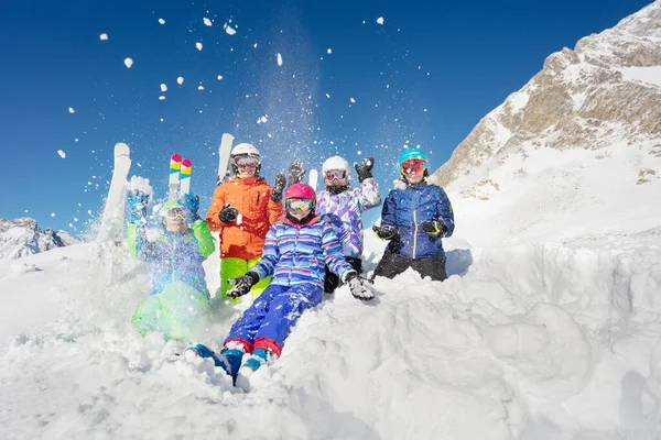 子供たちの楽しいグループの肖像画は アルプスの美しい山脈の上に空気中の雪を投げます — ストック写真