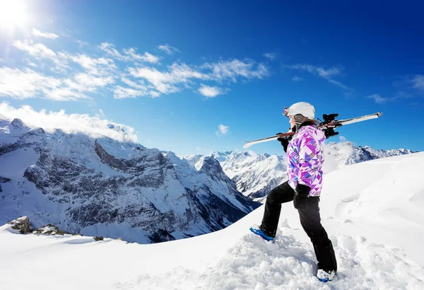 一个女孩站在高山滑雪者的顶上 站在滑雪板上 肩膀朝下看阳光灿烂的天气 — 图库照片