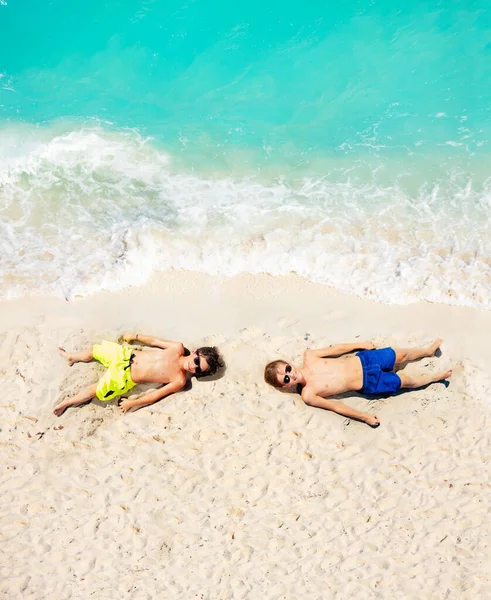 Vista Cima Dois Meninos Jazem Areia Praia Perto Água Mar — Fotografia de Stock