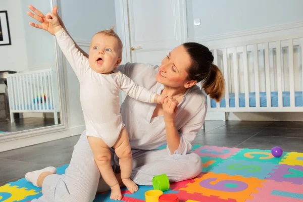 Glückliche Mutter Spielt Mit Kleinkind Kinderzimmer Und Hilft Ihm Aufzustehen — Stockfoto