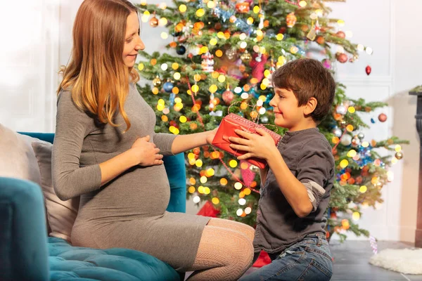 Julklapp Ger Tid Pojke Och Gravid Mor Nära Nyårsträd — Stockfoto