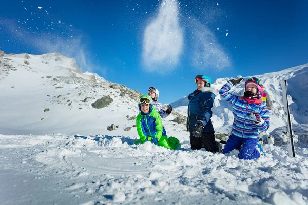 Grupa Dzieci Bawić Siedzieć Razem Ziemi Rzucać Śnieg Powietrzu Nad — Zdjęcie stockowe