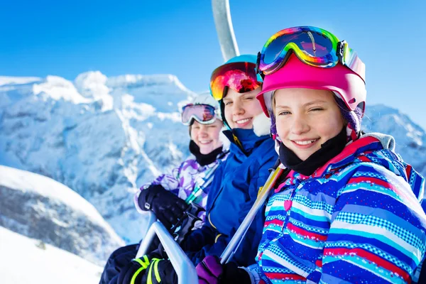 快乐微笑的女孩坐在轮椅上 头戴安全帽 身穿明亮的滑雪服 和朋友们一起在美丽的山顶上滑行 — 图库照片