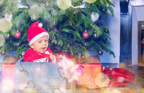 Junge Mit Nikolausmütze Und Beleuchteten Lampen Sitzt Schachtel Unter Weihnachtsbaum — Stockfoto