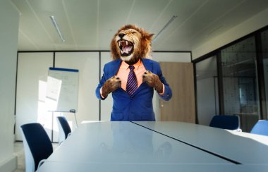 Kızgın patron konsepti, takım elbise standında aslan ve masanın yanında kükreyen pençeler kullanarak yırtık gömlek.