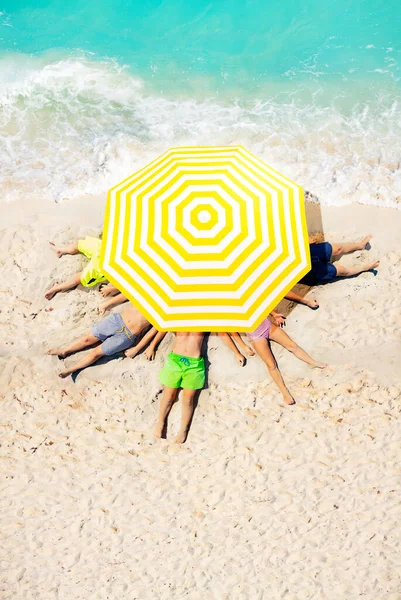 Group Kids Lay Beach Sand Big Sun Umbrella View Sea — Stock Photo, Image