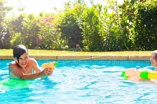 Junge Schwimmbad Schießt Sonnigem Sommertag Mit Wasserspritzpistole — Stockfoto