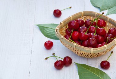 Eski ahşap bir masada olgun kirazlar. Böğürtlen topla. Metin için boşluk. beyaz tahta masa