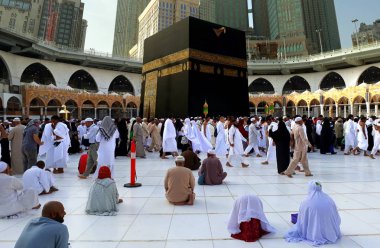 MAKKAH, SAUDI ARABIA - FEBRUARY 10, 2017: Muslim performing tawaf at holy Kaabah in the morning. Muslims face the direction of Kaaba when performing prayer clipart