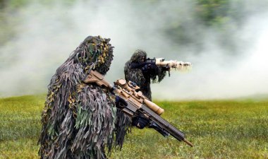Savaş sırasında ghillie kamuflajı giymiş askeri komando.