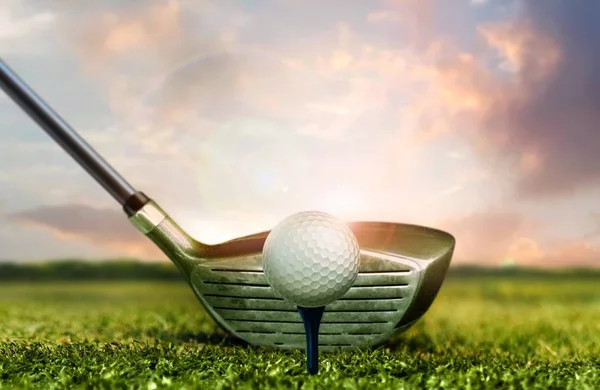 高尔夫球杆和球在草地上与日落天空灯下 — 图库照片