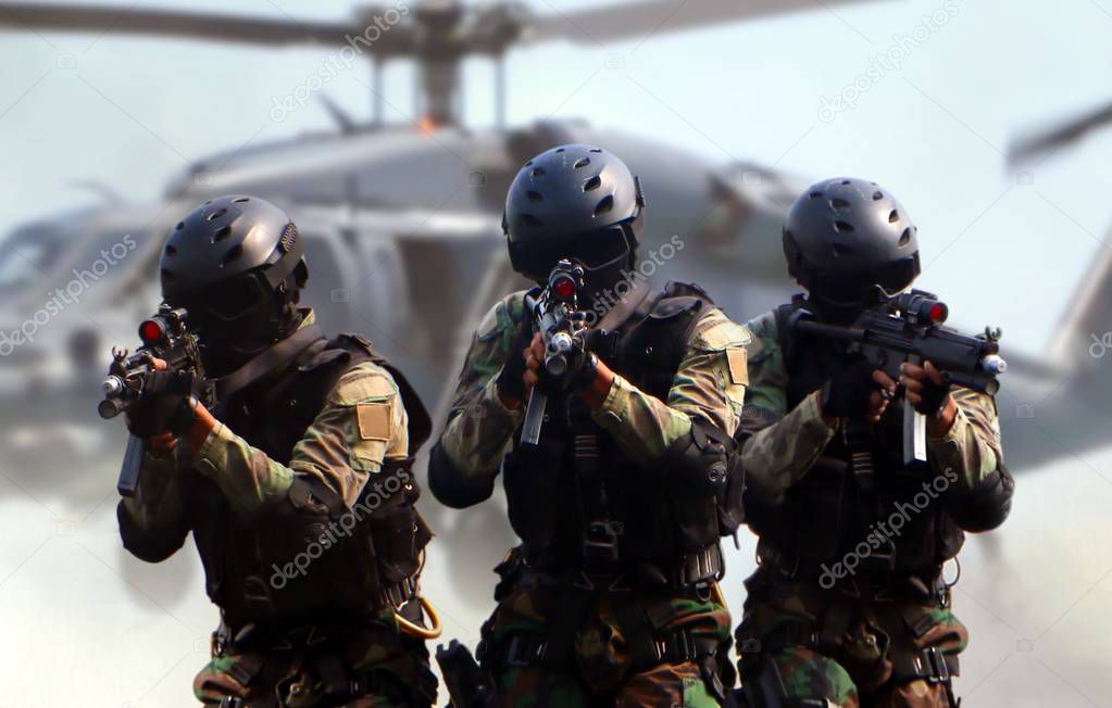 Special force assault team in a mission with helicopter background