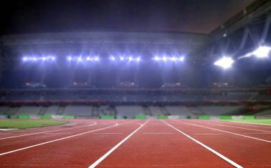 Running track in a stadium under bright spotlights clipart