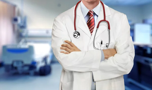 身穿医疗服的医生双手交叉地站在医院病房里 — 图库照片