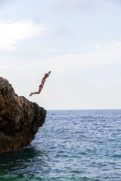Человек Прыгает Море Скалы — стоковое фото