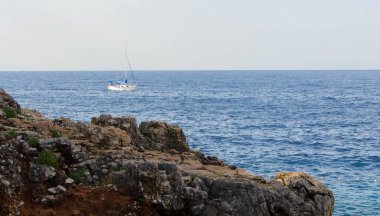 Kayaların üzerinden panoramik tekne ve güzel mavi deniz