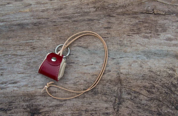 Colorfull leather key ring in the shape of mini bag on wooden background