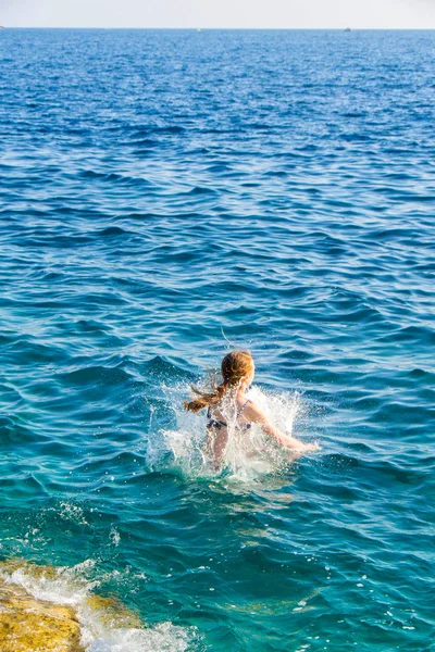 Junges Mädchen springt ins Meer — Stockfoto