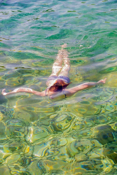 Молодая девушка плавает в море — стоковое фото