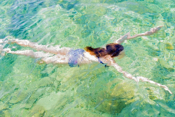 Jong meisje zwemmen in de zee — Stockfoto