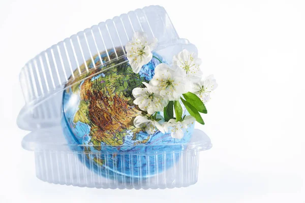 Plastic packaging absorbs planet earth. The concept of pollution by plastic debris. Isolated white background