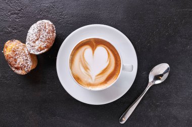 fincan krem kapuçino karanlık taş zemin üzerine bir kalp şeklinde, şeker ve krema şeker ile üstten görünüm