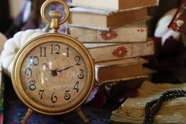 Eski masa saati ve kitap kapalı tablo