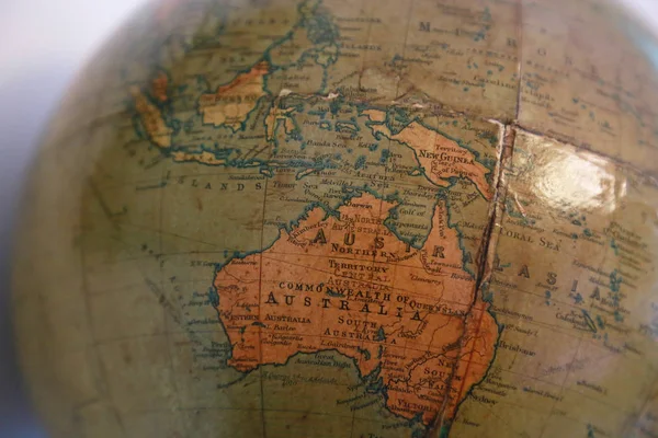 Old brown terrestrial globe with a view of the Australia Continent