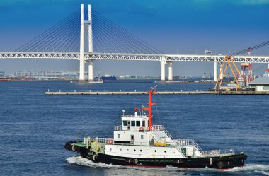 Bir köprü ve mavi bir gökyüzü ve o was para cezası Japonca Yokohama limanda port römorkör