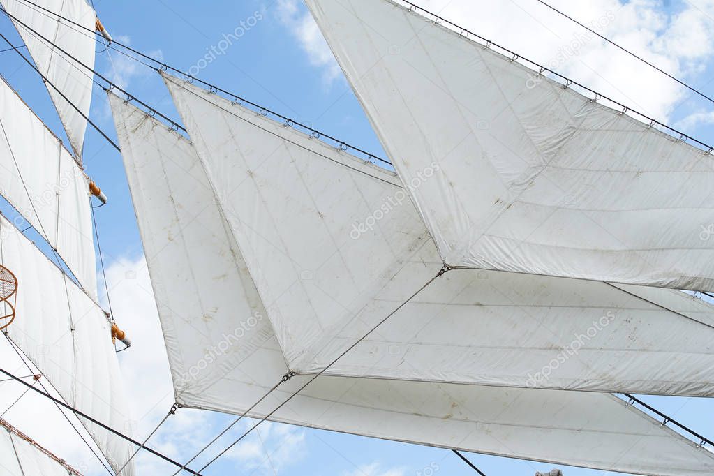Triangular sail of the sailing boat anchoring in the port of the blue sky which it was fine                               