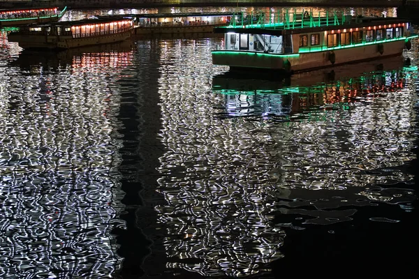 Japan`s night view of the reflected light of the light reflected on the water surface waves and the tourist boat