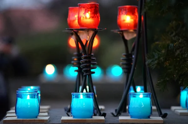 Orange and green candle lights in a glass container
