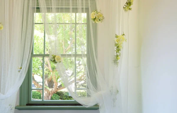 The yellow rose displayed to a window and the curtain of the room