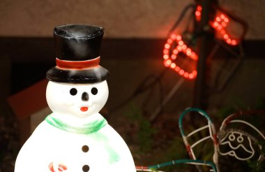 Noel süslemeleriyle aydınlatılan kardan adam.                               