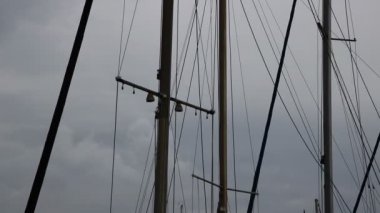 Bulutlu bir günde dalgalar üzerinde sallanan küçük tekne direkleri ayrıntılı bir görünümünü