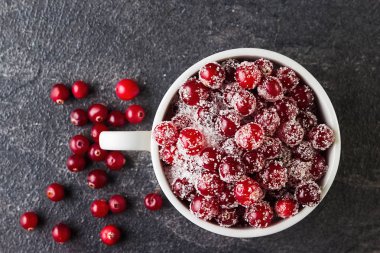 Siyah arka plan üzerinde şekerli kızılcık. Doğrudan yukarıdaki.