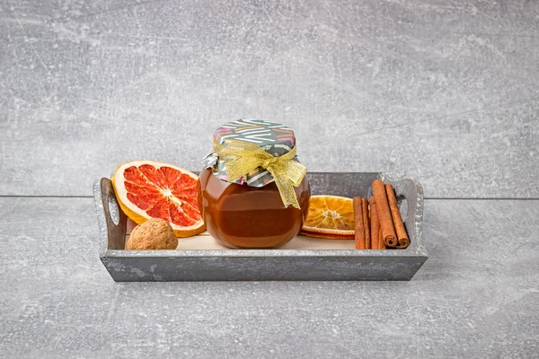 Jar of honey. Jar of caramel. Composition of Sweets. Orange and grapefruit, cinnamon and walnuts.