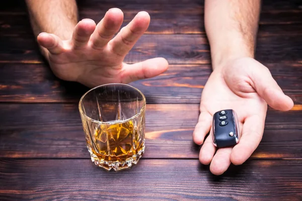 Drunk driving. Glass in man hands and car  keys. Drink and  auto keys.