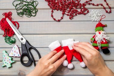 El yapımı Noel hediyeleri. Ahşap arka plan. Üst Manzara. Yeni yıl süsü hazırlıyorum. Noel süsleri. Küçük Noel Baba şapkaları.
