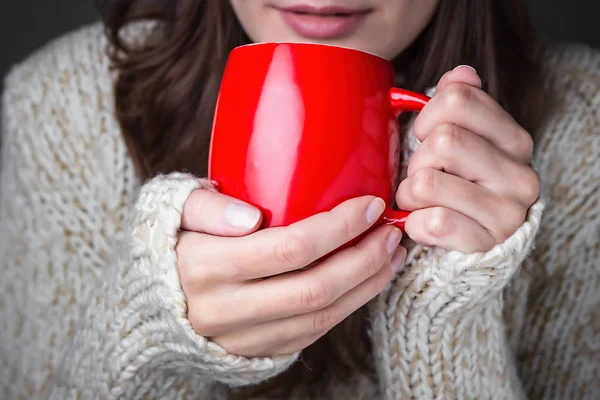 Kırmızı bir fincan kahve tutan bir ışık kazaklı kız — Stok fotoğraf